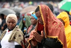 The faithful pray in the rain as Pope Francis celebrates Mass at Zimpeto Stadium in Maputo, Mozambique, Sept. 6, 2019.