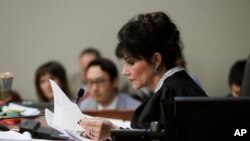 Judge Rosemarie Aquilina reads excerpts from the letter written by Larry Nassar during the seventh day of Nassar's sentencing hearing, Jan. 24, 2018, in Lansing, Mich. The former sports doctor who admitted molesting some of the nation's top gymnasts for years was sentenced Wednesday to 40 to 175 years in prison as Aquilina declared: "I just signed your death warrant."