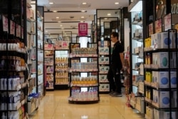 FILE - A salesman waits for customers at a cosmetic shop in a shopping district in Hong Kong, Oct. 30, 2019.