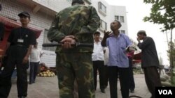 Seorang Uighur sedang menjelaskan kepada polisi Tiongkok mengenai alasan mengapa dia berjualan melon di Kashgar, selatan propinsi Xinjiang saat Ramadan, Agustus lalu (foto:dok).