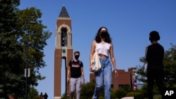 Masked students walk through the campus of Ball State University in Muncie, Ind., Sept. 10, 2020, as schools struggle to contain the virus. Out of nearly 600 students tested for the virus there, more than half have returned been found positive.