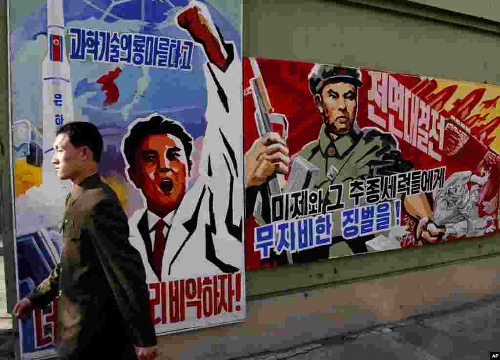 2013年3月26日,一位男士在平壤走过威胁要惩罚“美帝国主义者及其同伙”的宣传画。