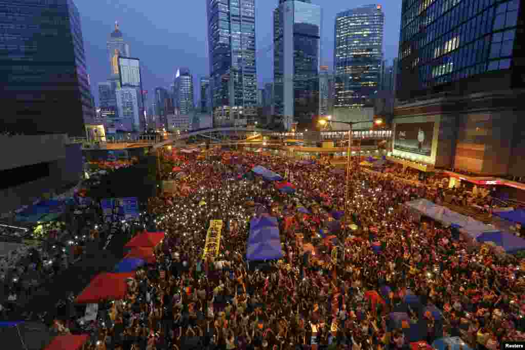 Pro-democracy demonstrators hold banners and shine light from their phones as they mark exactly one month since they took to the streets, in Hong Kong's financial district, Oct. 28, 2014.