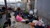 Para migran menunggu untuk mengajukan suaka di dekat pintu masuk Pelabuhan San Isidro, yang menghubungkan kota Tijuana, Meksiko dengan San Diego, California, AS.