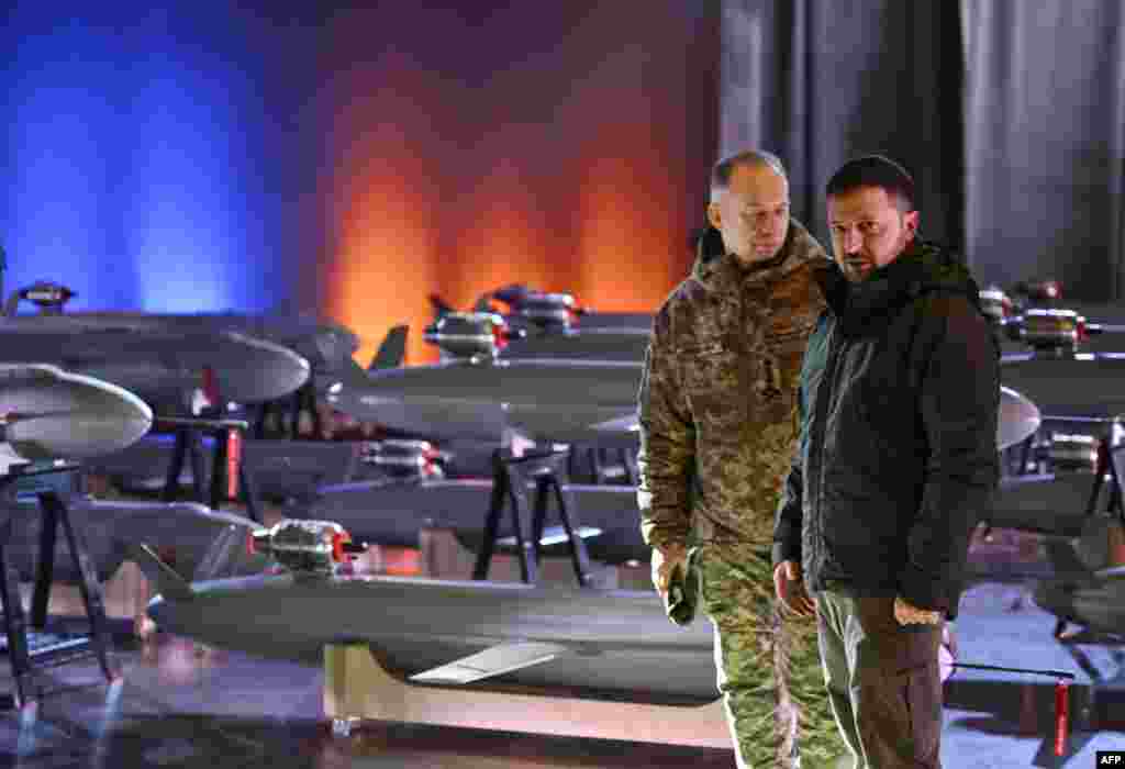 Ukrainian President Volodymyr Zelenskyy, right, and Commander-in-Chief of the Armed Forces of Ukraine Oleksandr Syrsky speak next to the first batch of Ukrainian-made drone missiles "Peklo" (Hell) in Kyiv.