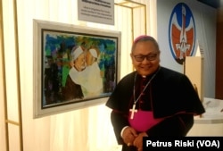 Uskup Surabaya, Mgr Agustinus Tri Budi Utomo, saat melihat galeri lukisannya, diantaranya perjumpaan Paus Fransiskus dengan Ahmed Al-Tayeb Imam Besar Al Azhar Kairo, Mesir. (Foto: Petrus Riski/VOA)