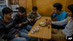 Para pelajar Kashmir belajar dengan menggunakan internet dari telepon genggam mereka di sebuah restoran di Srinagar, daerah Kashmir yang dikontrol oleh India, 26 April 2017. (AP Photo/Dar Yasin) 