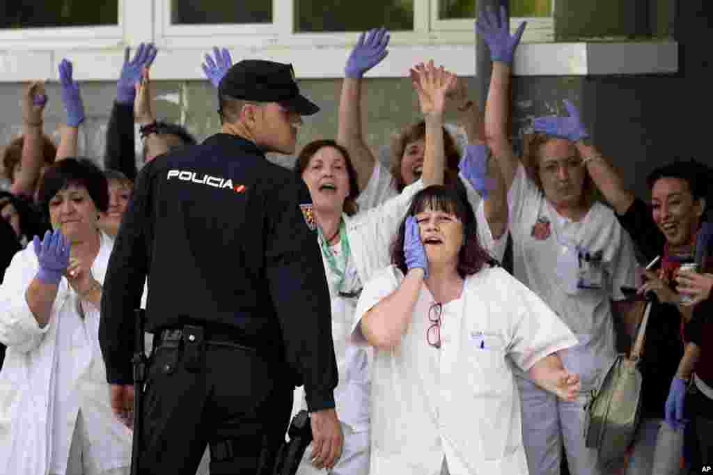 Medical practitioners call out to Spanish Prime Minister Mariano Rajoy during his visit to the Carlos III hospital in Madrid, Spain, Oct. 10, 2014.