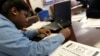FILE - A student at Roosevelt High School fills out a college enrollment application at her school in Washington, D.C., Nov. 14, 2013.