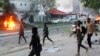 FILE - Security troops walk past burning cars after a fatal car bomb attack on a restaurant in Mogadishu, Somalia, May, 8, 2017. Al-Shabab militants claimed responsibility for the blast. Somalia's states on Sept. 8, 2018, suspended all ties with the central government, contending that it had taken its eye off the fight against al-Qaida-linked Islamist militants. 