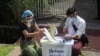 Officers from Union Election Commission arrange ballots for an early voting for upcoming Nov. 8 general election outside a residence on the outskirts of Yangon, Myanmar, Oct. 29, 2020.