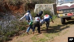 FILE - Myanmar Red Cross members carry an injured victim during clash between government troops and Kokang rebels in northeastern Shan State, northeast of Yangon, Feb. 17, 2015.