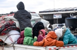 FILE - Civilians flee from Idlib toward the north to find safety inside Syria near the border with Turkey, Feb. 15, 2020.