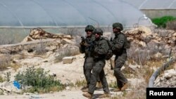 اعضای ارتش اسرائیل صحنه حادثه تیراندازی را در نزدیکی اریحا در کرانه باختری اشغالی اسرائیل، ۹ فروردین ۱۴۰۳ بازرسی می کنند.