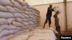 FILE - Men transport humanitarian food aid onto trucks in Sevare, Feb. 4, 2013. 