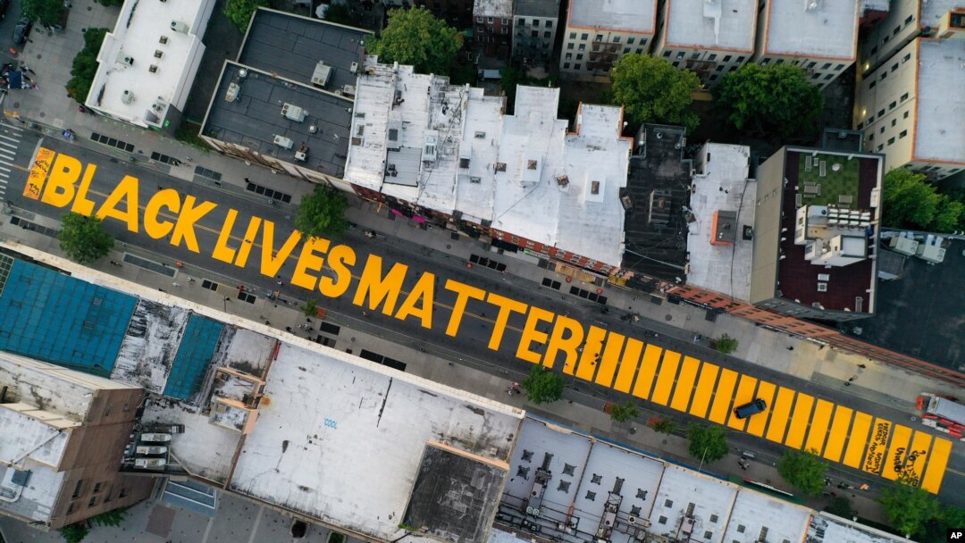 FILE - A giant "Black Lives Matter" sign is painted on Fulton Street, in the Brooklyn borough of New York City, June 15, 2020. 