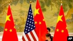 在北京钓鱼台国宾馆，中国工作人员在中美贸易谈判开幕式前调整中国和美国的国旗（2019年2月14日）。