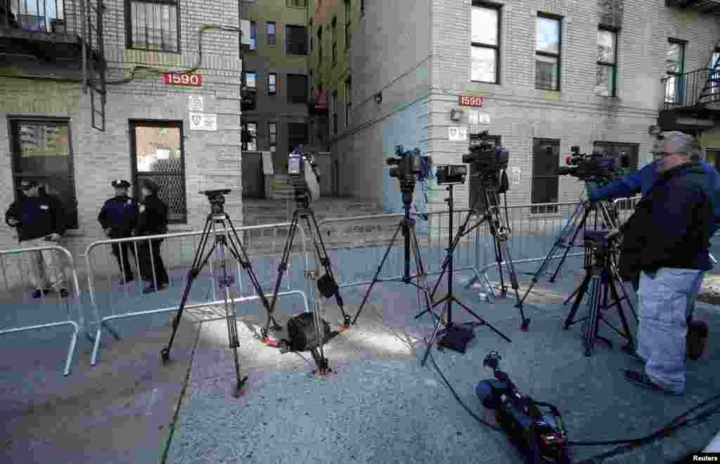 Media and police stand outside a Bronx, New York apartment building from where a 5-year-old boy who arrived from Guinea was taken to Bellevue Hospital in New York to be tested for the Ebola virus, Oct. 27, 2014.