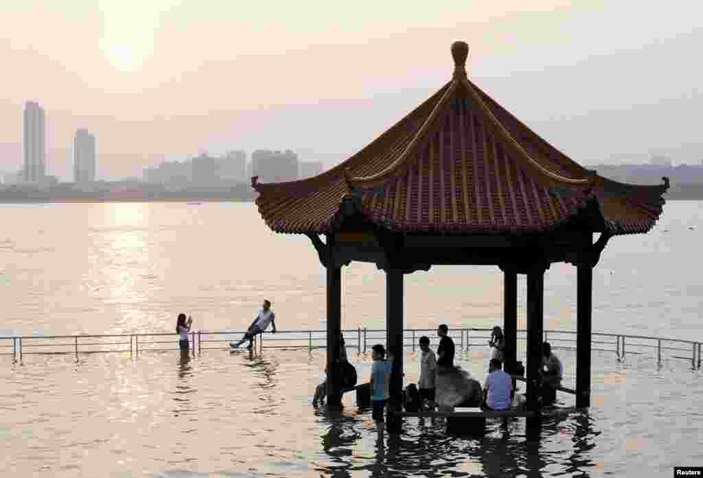 2015年6月19日,湖北武汉,长江涨水,水漫亭台,有人留影。 湖北常闹水灾的直接原因是湖泊大量消失,消失的原因是过去的围湖造田和后来的填湖建房。