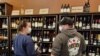 Sarah Robinett and her husband stop by UnWind in Alexandria, Virginia to pick up some bottles of wine. (Photo: Deborah Block / VOA)