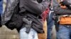 FILE - Men stand with pistols strapped at their sides at a gun rights rally on the steps of the Washington state capitol in Olympia, Washington, Jan. 15, 2016.