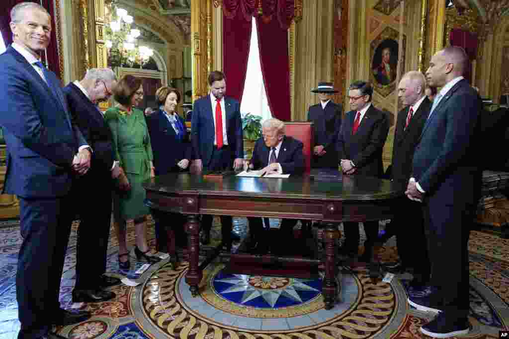 President Donald Trump, center, takes part in a signing ceremony in the President's Room, Jan. 20, 2025, at the U.S. Capitol in Washington.