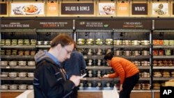FILE - Shoppers roam through an Amazon Go store.