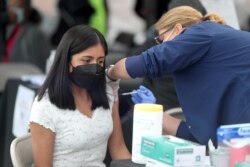 Seorang perempuan sedang divaksinasi untuk melawan COVID-19 di Jordan Downs, Los Angeles, California, 10 Maret 2021.