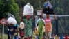 People displaced by fighting between Congolese forces and M23 rebels make their way home after spending a night in the Ugandan town of Bunagana, Oct. 31, 2013.