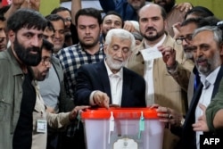Kandidat presiden Iran dan mantan negosiator nuklir ultrakonservatif Saeed Jalili (tengah) memberikan suara di tempat pemungutan suara di Teheran pada 5 Juli 2024. (Foto: AFP)