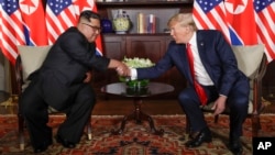 Presiden AS Donald Trump (kanan) dan Pemimpin Korea Utara Kim Jong Un dalam pertemuan di Singapura hari Selasa (12/6). 