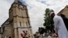 Muslim worshipers hold a minute of silence in front of a memorial at the Saint Etienne church in St. Etienne du Rouvray, Normandy, France, July 29, 2016, where Catholic priest Jacques Hamel was killed by Islamist attackers.