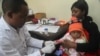 FILE - A doctor tests a child for malaria at a hospital in Arusha, Tanzania, May 11, 2016. 