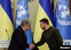 Presiden Ukraina Volodymyr Zelenskiy dan Sekretaris Jenderal PBB Antonio Guterres berjabat tangan setelah jumpa pers bersama, di tengah serangan Rusia terhadap Ukraina, di Kyiv, Ukraina, 8 Maret 2023. (Foto: REUTERS/Alina Yarysh)
