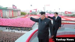 지난 10일 노동당 창건 70주년을 맞아 평양 김일성광장에서 열린 열병식에서 김정은 북한 국방위원회 제1위원장이 군중을 향해 손을 흔들고 있다.