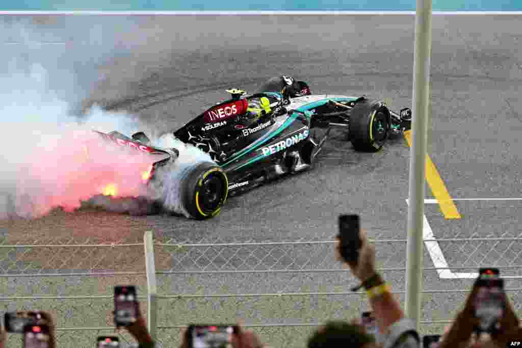Mercedes' British driver Lewis Hamilton performs a burn out after the Abu Dhabi Formula One Grand Prix at the Yas Marina Circuit in Abu Dhabi, United Arab Emirates.