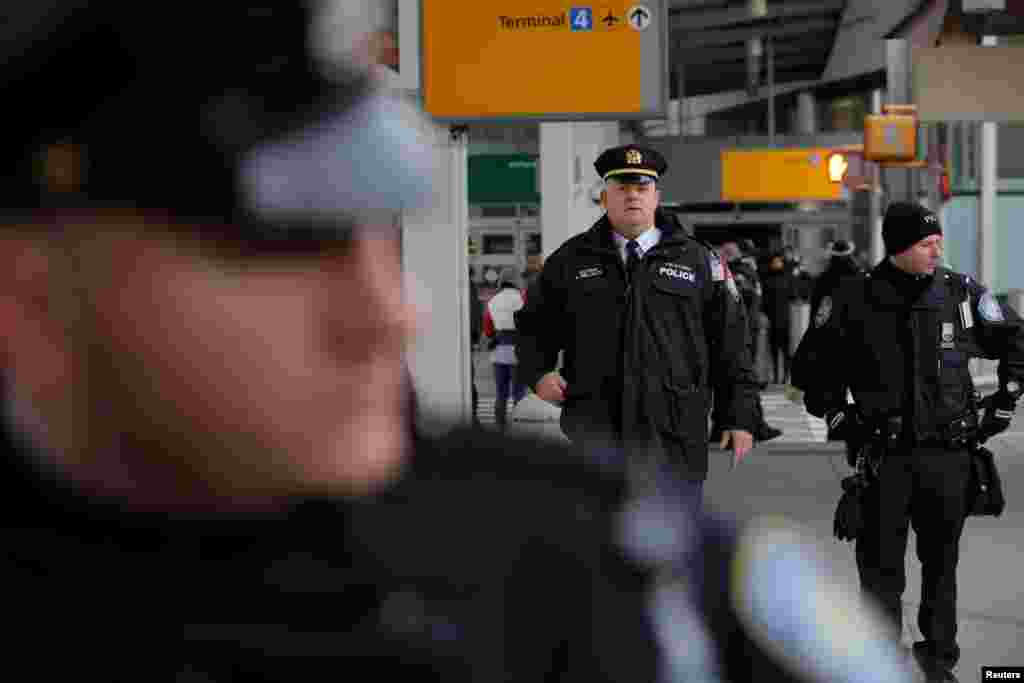 Polisi berjaga-jaga di pintu masuk selama demonstrasi melawan larangan imigrasi Presiden AS Donald Trump, di luar Terminal 4 Bandar Udara Internasional John F. Kennedy di Queens, New York (28/1). (Reuters/Andrew Kelly)