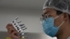 An employee inspects syringes of the SARS CoV-2 Vaccine for COVID-19 produced by SinoVac at its factory in Beijing, Sept. 24, 2020.