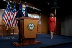 FILE - Senate Minority Leader Charles Schumer (D-NY) speaks to reporters with Speaker of the House Nancy Pelosi looking on, on Capitol Hill in Washington, Dec. 20, 2020.