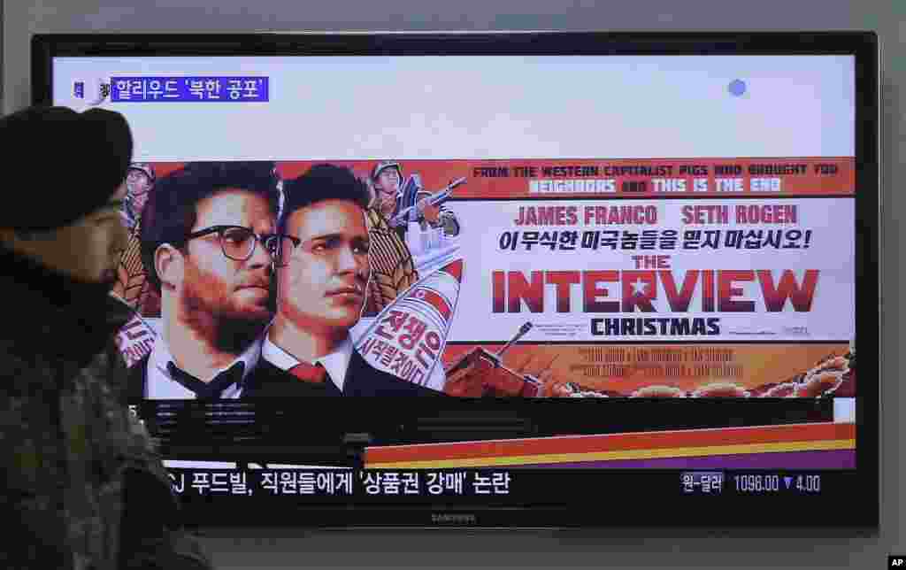 Seorang tentara Korea Selatan melewati iklan film "The Interview" dari Sony Pictures di stasiun kereta Seoul (22/12). (AP/Ahn Young-joon)
