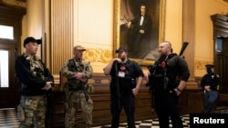 Michael John Null dan Willam Grant Null (kanan) yang didakwa 8 Oktober 2020 atas keterlibatan mereka dalam komplotan penculikan gubernur Michigan, menyerang gedung DPR negara bagian dan menghasut kekerasan, berdiri di dekat pintu kamar di gedung DPR. (Foto: Reuters)