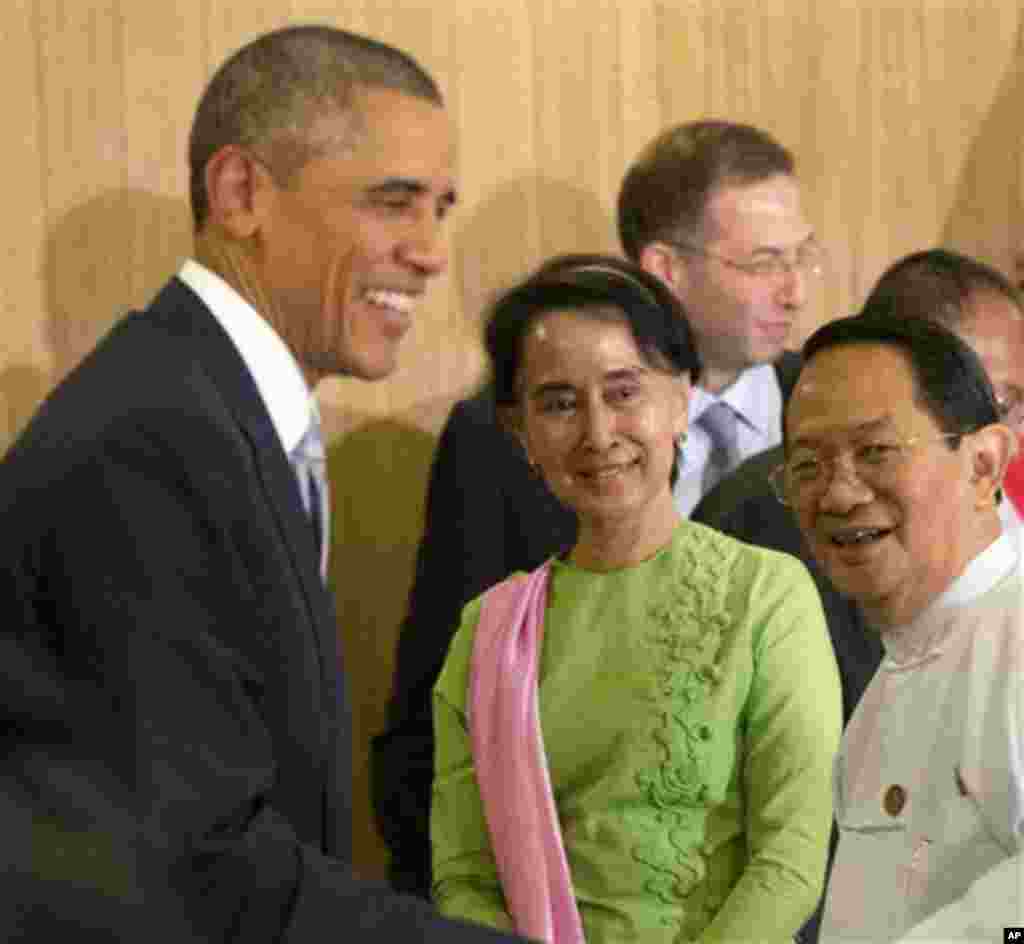 Myanmar's opposition leader Aung San Suu Kyi (center) looks on as President Barack Obama greets participants following a meeting at the Parliamentary Resource Center, Naypyitaw, Myanmar, Nov. 13, 2014.