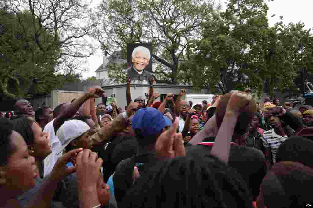 Crowds sing and chant outside Mandela's Houghton home in South Africa. (Hannah McNeish for VOA)