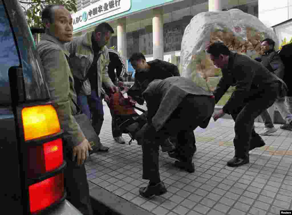 2013年1月10日,在广州《南方周末》总部附近,一名抗议者被便衣警察带走,塞入一辆吉普车。