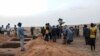 FILE - Officials and residents stand near freshly dug graves on June 11, 2019, in a Dogon village in Mali after an attack on ethnic Dogon on June 9, 2019. 