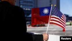 FILE - A demonstrator holds flags of Taiwan and the United States in Burlingame, California, Jan. 14, 2017.
