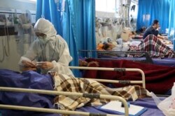 A medic treats a patient infected with the new coronavirus, at a hospital in Tehran, Iran, March 8, 2020.