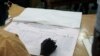 As Nigerians await results in the tightest and most bitterly contested presidential election in the nation's history, a Nigerian election official reads local results in Kaduna, March 30, 2015.