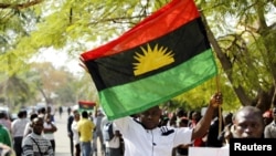 FILE - A man holds a Biafra flag during a rally in Abuja, Nigeria, Dec. 1, 2015.