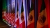 FILE - From left, the national flags of Canada, the U.S. and Mexico are illuminated by stage lights ahead of a news conference at the start of trilateral trade talks in Washington, Aug. 16, 2017. 